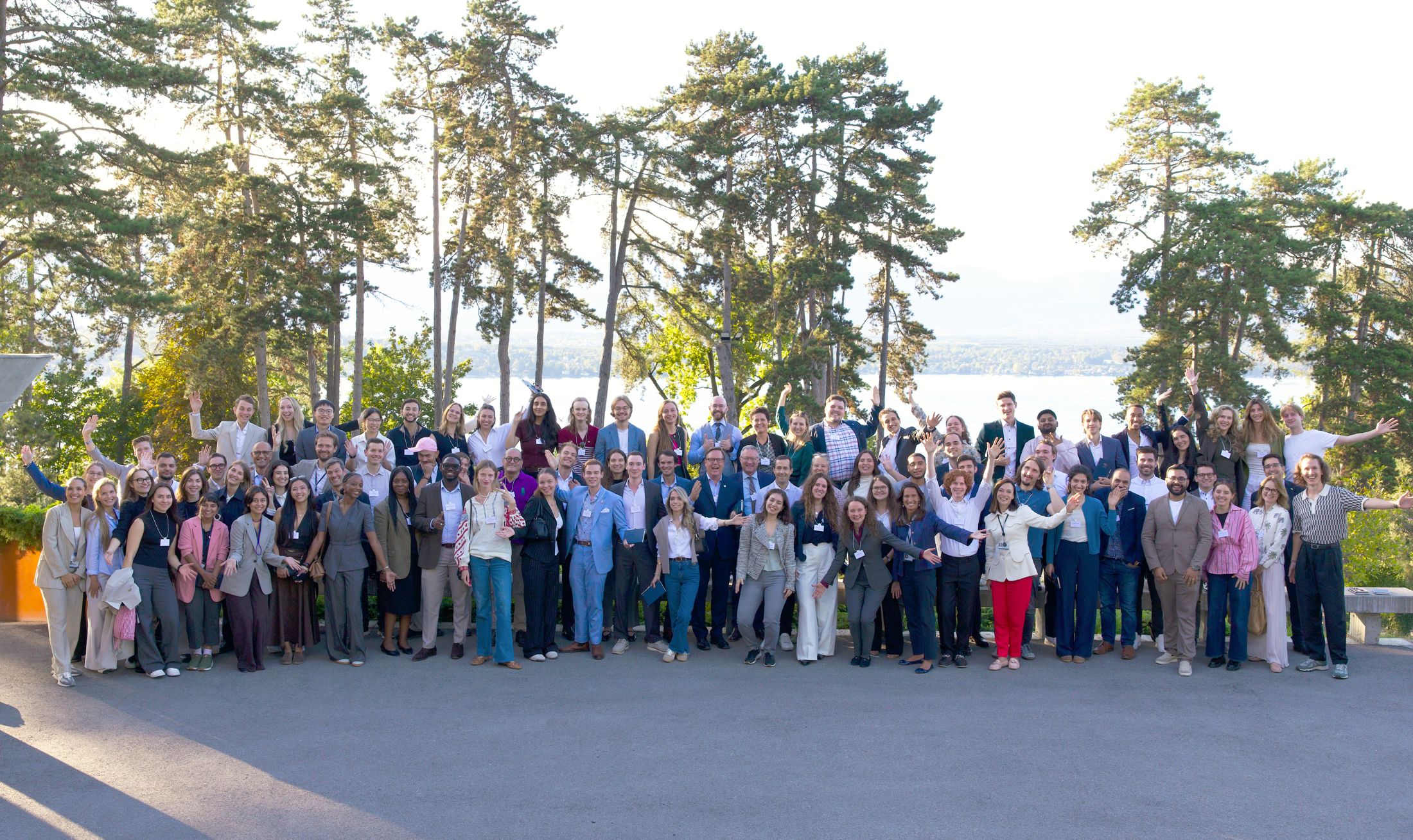 Around a hundred Global Shapers posing together in a park above Lake Geneva